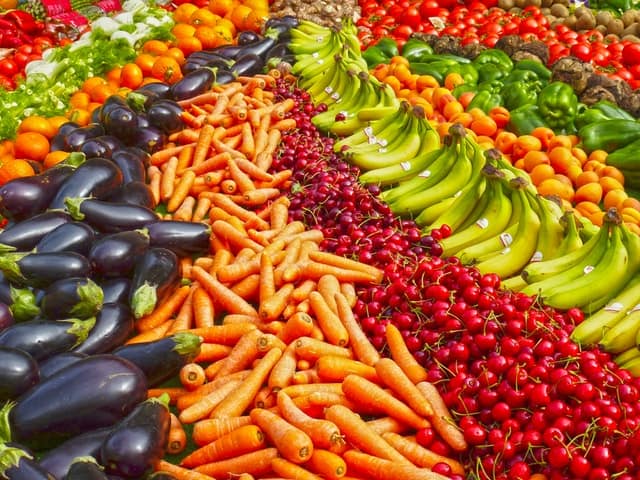 stand avec carottes, bananes, cerises, poivrons, aubergines