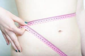 Taille fine, mesurant la taille par un pouce