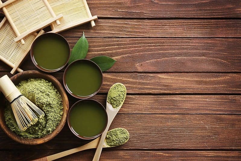 hé vert matcha en poudre dans une salade et des tasses de liquide