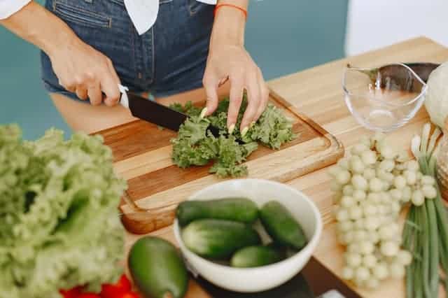 femme coupant des légumes