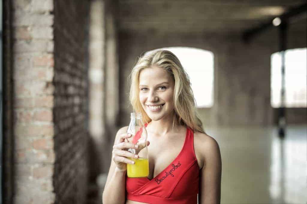 Une femme boit une boisson aux agrumes